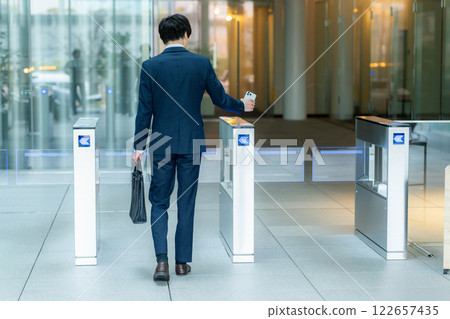 Office worker passing through security gate Office worker passing through security gate 122657435