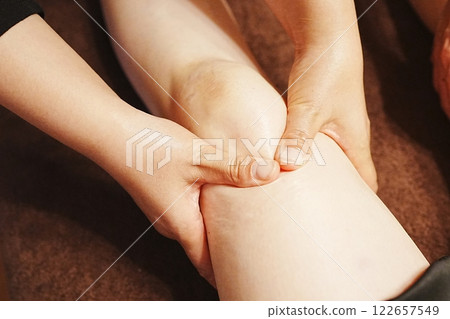 Knee oil massage, lying on back Knee oil massage, lying on back 122657549
