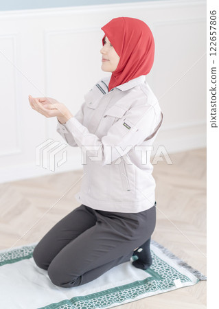 Young woman praying in the prayer room at her workplace 122657806