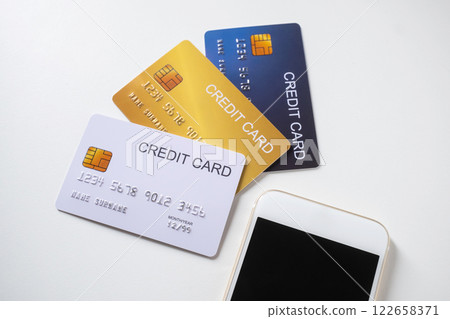 Pile of credit cards with smartphone on white background. Cashless technology and credit card payment concept. 122658371
