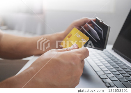 Close-up of hand holding credit card from wallet to online shopping. Cashless technology and credit card payment concept. Close-up of hand holding credit card from wallet to online shopping. Cashless technology and credit card payment concept. 122658391