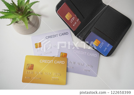 Pile of credit cards with smartphone and cactus on white table. Cashless technology and credit card payment concept 122658399