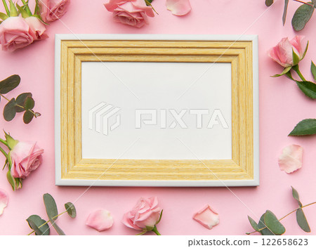 Wooden frame decorated with pink roses and eucalyptus leaves on pink background for valentine's day 122658623