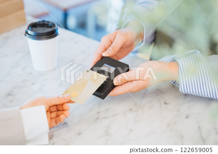 A woman's hand purchasing and paying for takeaway coffee using an IC chip payment 122659005