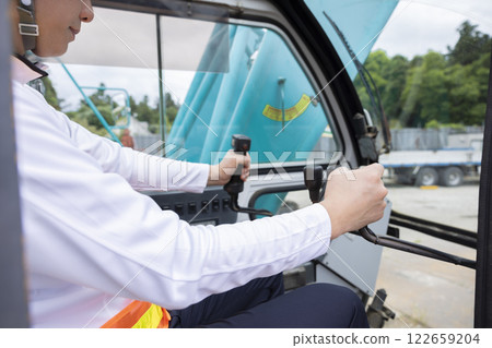 The hands of a man operating a crane 122659204