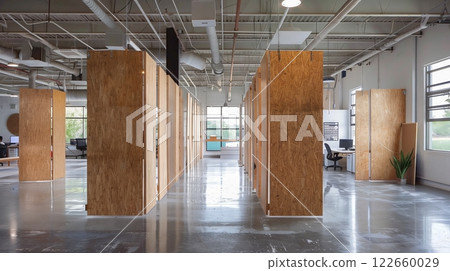 Thick plywood dividers partition an industrial space, creatively blending openness, privacy, and collaboration. Thick plywood dividers partition an industrial space, creatively blending openness, privacy, and collaboration. 122660029