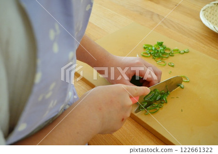 一名小學生用刀切蔥 122661322