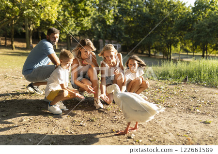 Family enjoying a day at the park feeding ducks 122661589