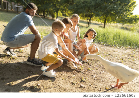 Family enjoying outdoor time with curious goose 122661602