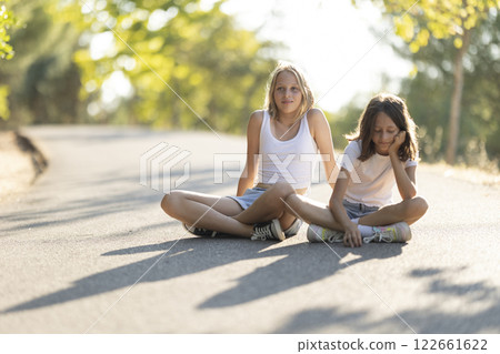 Two children relaxing on a sunlit pathway 122661622