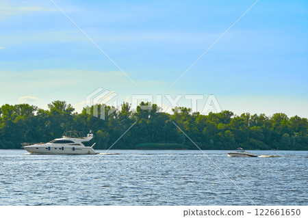 Sunny summer warm river and pleasure boats and yachts Sunny summer warm river and pleasure boats and yachts 122661650