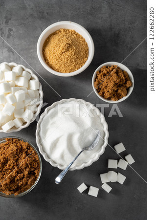Different type of sugar, light brown, dark brown and white sugar cubes in bowls. Different type of sugar, light brown, dark brown and white sugar cubes in bowls. 122662280
