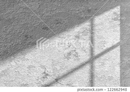 A concrete textured wall with natural shadows from sunlight coming through a window that can be used in various designs. A concrete textured wall with natural shadows from sunlight coming through a window that can be used in various designs. 122662948