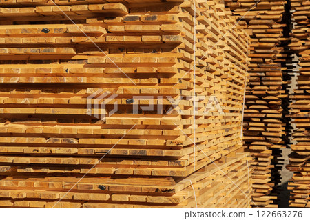 A stack of boards. The boards are stacked on the sawmill. Sawing boards on a sawmill. Production of wood material A stack of boards. The boards are stacked on the sawmill. Sawing boards on a sawmill. Production of wood material 122663276