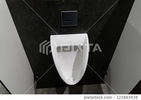 Minimalist urinal situated in a clean, modern restroom, highlighting hygiene and comfort in a public setting for male users 122663438
