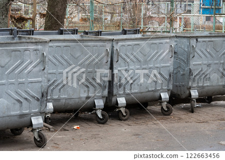 In a busy city, metal recycling bins stand side by side, ready to collect waste and support environmental conservation In a busy city, metal recycling bins stand side by side, ready to collect waste and support environmental conservation 122663456