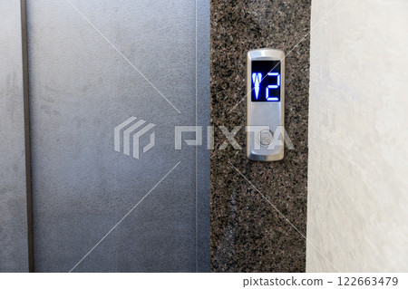 Modern elevator controls seamlessly integrated into a stylish apartment building with illuminated buttons indicating the floor selection 122663479