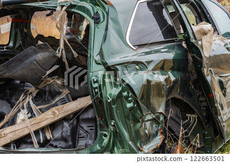 A damaged car is left abandoned on the side of a suburban road, highlighting the consequences of a severe crash and the need for safety 122663501