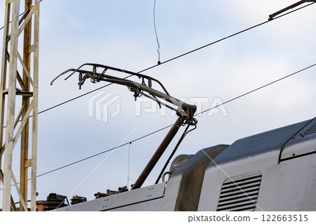 The overhead conductor of a modern electric train stretches above the railway, ready for transportation operations at the station 122663515