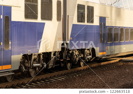 A sleek electric locomotive arrives at the platform, ready to transport passengers at a busy modern railway station in the afternoon light 122663518
