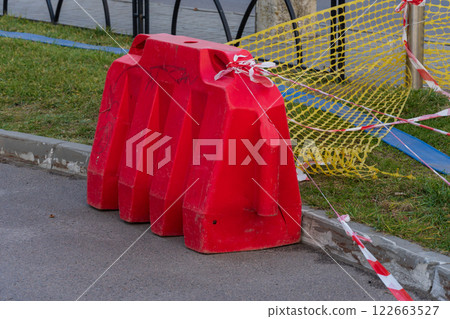 Construction barriers and caution tape are set up around a work site in the city, alerting pedestrians to stay clear of the area Construction barriers and caution tape are set up around a work site in the city, alerting pedestrians to stay clear of the area 122663527