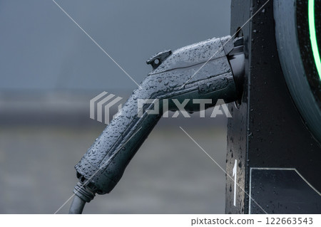 A wet electric car charging connector highlights the advancements in sustainable transportation technology and electricity usage today A wet electric car charging connector highlights the advancements in sustainable transportation technology and electricity usage today 122663543