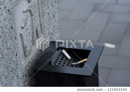 Cigarette butts are discarded in a waste container, emphasizing the ongoing need for better waste management practices in urban areas 122663549
