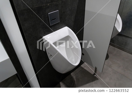 A clean, minimalist restroom showcasing a modern urinal design, emphasizing hygiene and sanitation in a public facility 122663552
