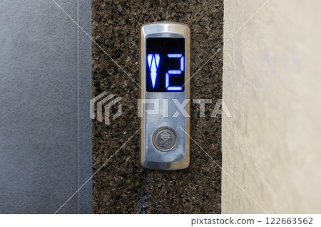 Control panel for an elevator shows illuminated floor number 2, showcasing sleek technology in a modern apartment setting 122663562