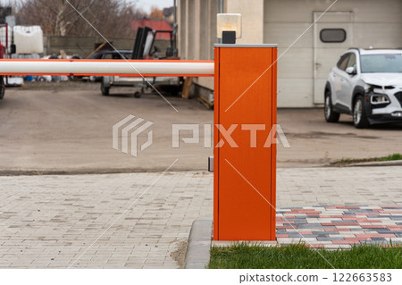 An automatic gate stands closed at the entrance of a parking lot, providing secure access control and enhancing safety for vehicles An automatic gate stands closed at the entrance of a parking lot, providing secure access control and enhancing safety for vehicles 122663583