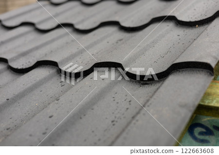 Close-up view of modern metallic roofing tiles, highlighting the unique texture and durability of the material used for home construction 122663608