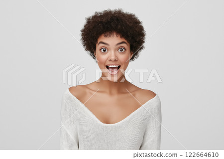A studio portrait of a woman expressing awe, with her mouth slightly open and eyes wide 122664610