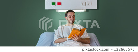Man, patient sitting in hospital bed in gown and reading book against green background. Positive recovery process Man, patient sitting in hospital bed in gown and reading book against green background. Positive recovery process 122665575
