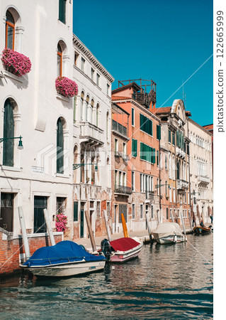 A row of colorful buildings with a blue boat in the middle. 122665999