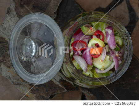 Homemade thai cucumber slices, chili slices and shallots relish slices and vinegar in a glass jar. 122666385