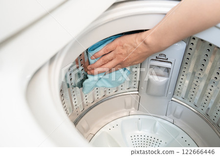 Woman cleaning the washing machine Woman cleaning the washing machine 122666446