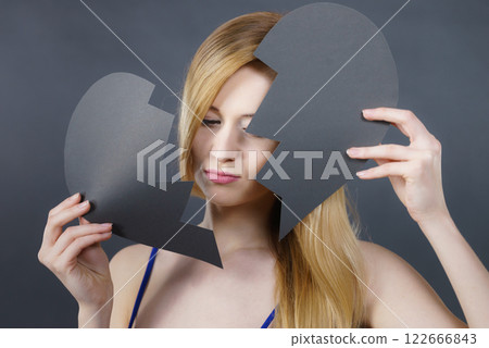 Young sad woman covered by broken heart. 122666843