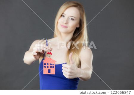 Woman holding key with house symbol Woman holding key with house symbol 122666847