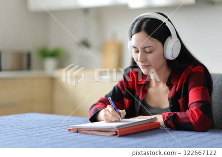Asian student listening lesson and taking notes Asian student listening lesson and taking notes 122667122