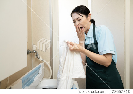 一位女士擔心洗完的 T 恤上的污漬洗不掉。 122667748