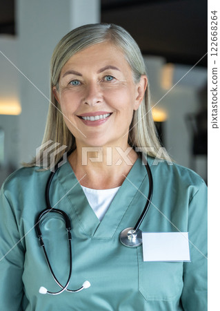 Waist up of a confident mature female doctor in a medical scrubs 122668264