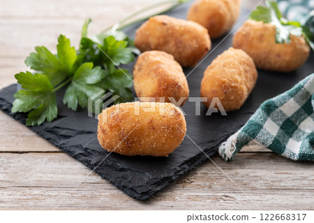 Fried cod croquettes on wooden table Fried cod croquettes on wooden table 122668317