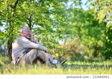 Portrait of senior couple sitting on the grass in the park Portrait of senior couple sitting on the grass in the park 122668461
