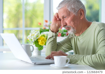 Portrait of senior man with laptop at home 122668479
