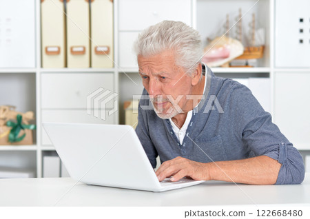 Portrait of senior man with laptop at home Portrait of senior man with laptop at home 122668480