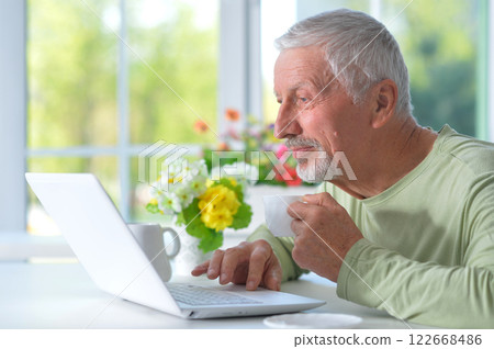 Portrait of senior man with laptop at home Portrait of senior man with laptop at home 122668486