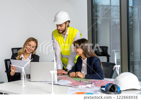 Group of people working in the office on a new green energy project 122668938