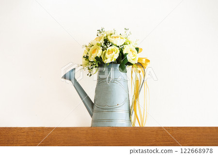 Yellow roses in a classic watering pot on wooden background, isolated white background. Yellow roses in a classic watering pot on wooden background, isolated white background. 122668978