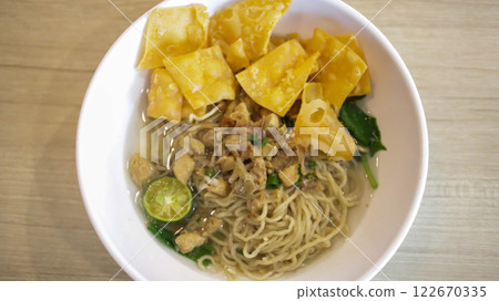 A mouthwatering bowl of Mie Ayam, a popular Indonesian dish yellow wheat noodles with diced chicken, mushrooms, and an array of savory condiments. A delightful blend of Chinese and Indonesian flavors. A mouthwatering bowl of Mie Ayam, a popular Indonesian dish yellow wheat noodles with diced chicken, mushrooms, and an array of savory condiments. A delightful blend of Chinese and Indonesian flavors. 122670335