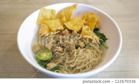 A mouthwatering bowl of Mie Ayam, a popular Indonesian dish yellow wheat noodles with diced chicken, mushrooms, and an array of savory condiments. A delightful blend of Chinese and Indonesian flavors. A mouthwatering bowl of Mie Ayam, a popular Indonesian dish yellow wheat noodles with diced chicken, mushrooms, and an array of savory condiments. A delightful blend of Chinese and Indonesian flavors. 122670336